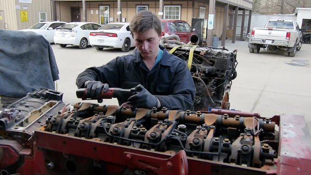 Mechanic working on semi truck diesel truck engine in garage