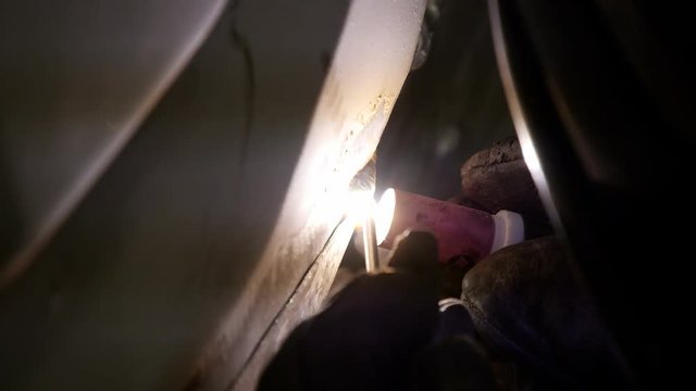 Close up of mechanic welding on semi truck in garage truck shop