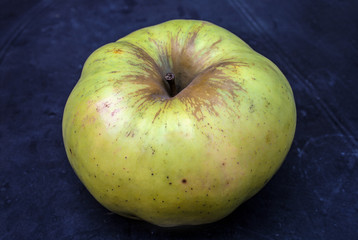 Live green apple on a dark blue background