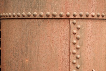 Rusty metal background with large rivets