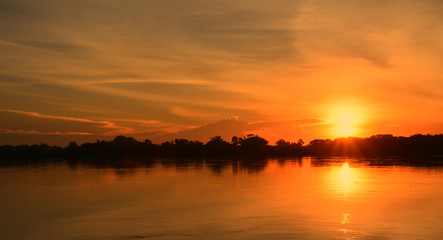 Beautiful sunset on the river bank./The sun is setting on the banks of the river. Create a...