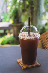 Iced americano coffee on the table in the garden cafe.