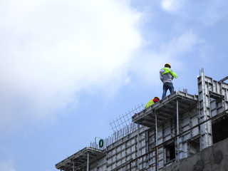 Construction workers working at height without wearing proper safety gear like body harness. This dangerous act can cause accidents and death.