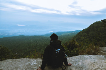 Fototapeta premium Men asians travel relax in the holiday. Admire the atmosphere landscape on the Moutain. Mountain Park happily. In Thailand