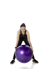 Arabian woman exercising with fitness ball on studio