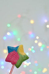 A colorful star shape candy with a out of focus light background