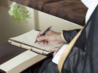 Saudi Arabian Man Hand Writing on A Notebook