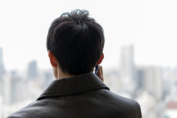 企業からの電話を受ける就活生の後ろ姿