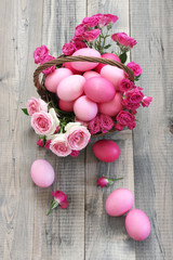 Varicolored pink Easter eggs in wicker basket