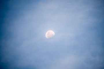 Waxing gibbous moon at night with illuminated sky