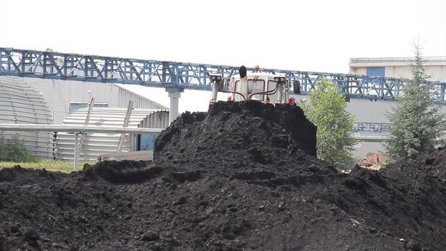Tractor on production of coal in a traditional manner\bulldozer rakes coal