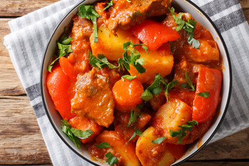 Filipino cuisine: Mechado beef with vegetables in spicy sauce close-up in a bowl on the table. horizontal top view from above