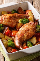 Homemade dietary rabbit baked with vegetables close-up in a baking dish on a table. vertical