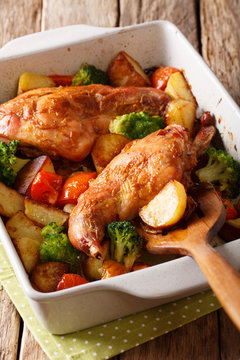 rabbit baked with vegetables in mustard sauce close-up in baking dish on table. vertical