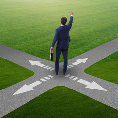Young businessman at crossroads in uncertainty concept