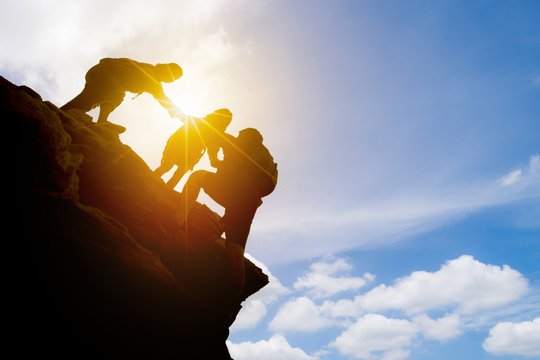 Asia Couple Hiking Help Each Other Silhouette In Mountains With Sunlight.