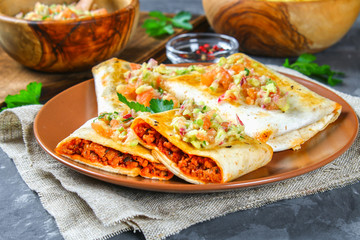 Traditional Mexican dish - chimichanga. Corn cake with minced meat, pepper, onion, garlic, oregano, zira and guacomole sauce from avocado.