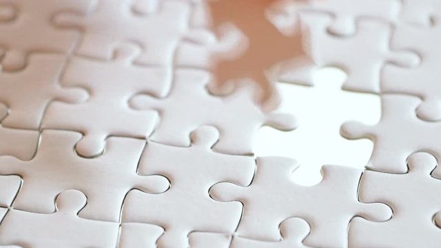 last piece of white plain jigsaw filling by hand, step of success concept