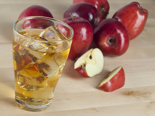 A Glass of Fresh Cold Apple Juice with Ice Beside Apples on A Wooden Table