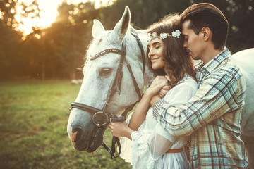Young happy couple and beautiful horse