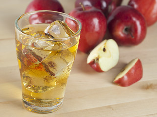 A Glass of Fresh Cold Apple Juice with Ice Beside Apples on A Wooden Table