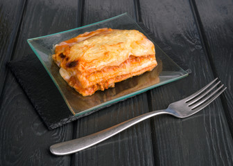baked lasagna on black wooden board