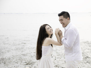 Young Asian couple in love on the beach.