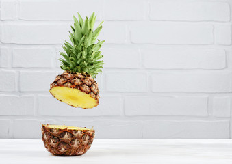 Fresh ripe flying cut juicy pineapple on gray brick wall background