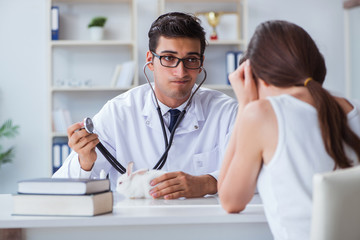 Obraz premium Woman with pet rabbit visiting vet doctor