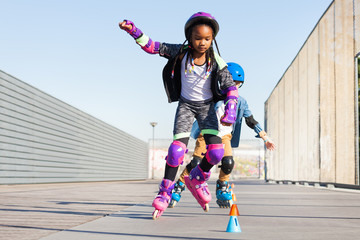 Fototapeta na wymiar Girl learning to slalom skate with inline skates