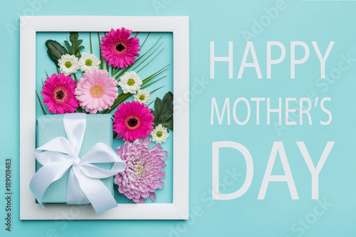 Happy Mother's Day Pastel Candy Colors Background. Floral mothers day flat lay minimal concept with beautifully wrapped present.