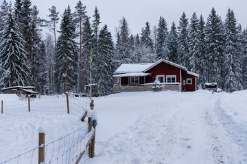 Fototapeta premium red wooden house in a snowy and cold varmland sweden