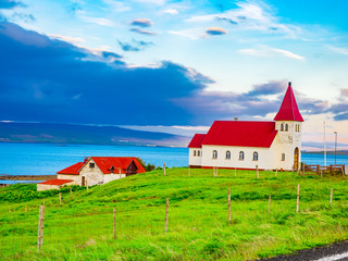 Small church on green grass field at seaside