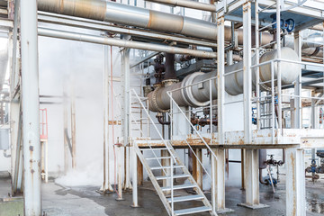 Fragment of the technological installation in the factory. Steam leak.