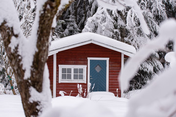 red wooden house in a snowy and cold varmland sweden