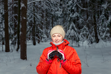 Fototapeta na wymiar beautiful woman tourist with binoculars in a winter forest