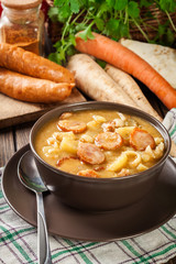 Traditional Polish split pea soup with sausage, bacon and potatoes