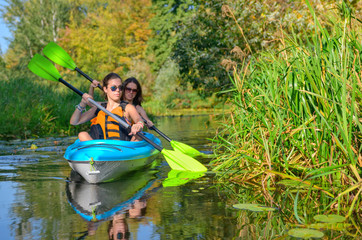 Family kayaking sport, mother and child paddling in kayak on river canoe tour, active autumn...