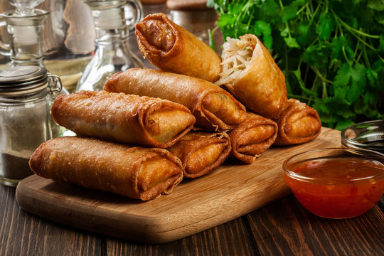 Spring rolls with chicken and vegetables on chopping board