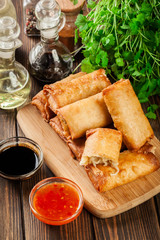 Spring rolls with chicken and vegetables on chopping board