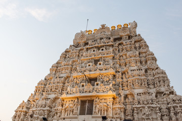 Ancient temple tower view of Kanchi kamakshi amman temple illuminated with lights. Low light photography during sunset.
