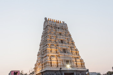 Ancient temple tower view of Kanchi kamakshi amman temple illuminated with lights. Low light photography during sunset.
