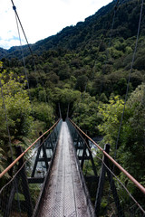 Fototapeta na wymiar New Zealand Fox Glacier old historic wooden swing bridge