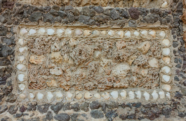 original rectangle of seashells and marine sponges on a stone wall /geometric composition with shells and marine sponges