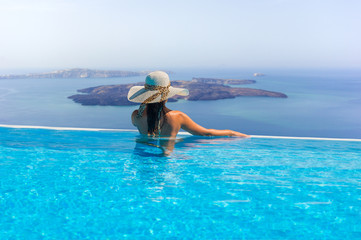 Woman enjoying relaxation in pool and looking at the view