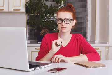 Thoughtful successful young female copywriter tries to get good ideas for new project, puts down...