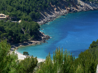 Obraz premium Mallorca, Balearic Islands, a hidden cove between rocks covered with Mediterranean bush in spring