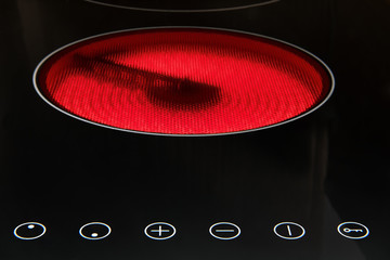 Modern induction cooker with control buttons. The electric hob closeup. Stove top panel at modern...