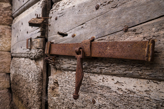 Close up of a rusty sliding block latch of an old wooden door. Marche region, Italy