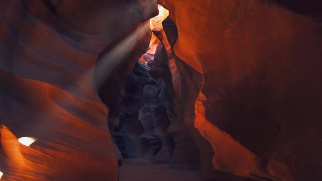 tilt down and across shot of a sun beam on a canyon wall at upper antelope canyon in page, arizona